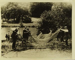 Photograph of men cleaning a fishing net, Windsor Great Park at Virginia Water Photograph of men cleaning a fishing net, Windsor Great Park at Virginia Water