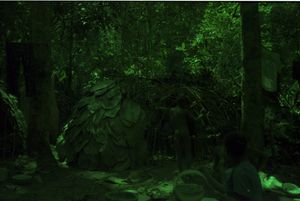 A child with his or her back to the camera standing next to a partly constructed dome-shaped shelter. A child with his or her back to the camera standing next to a partly constructed dome-shaped shelter.