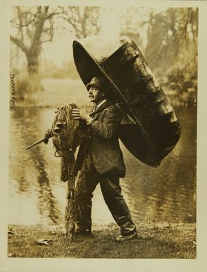 Photograph of a fisherman carrying his equipment Photograph of a fisherman carrying his equipment