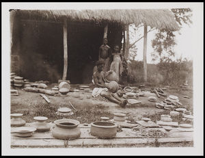 1 female and 2 children standing among a large collection of pots 1 female and 2 children standing among a large collection of pots